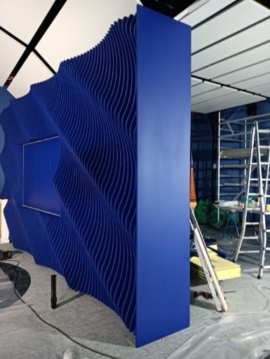 Panel acústico ondulado azul montado en estructura del plató